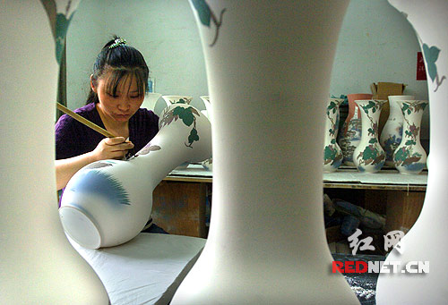 醴陵醴泉窯藝的工人正在描繪釉下彩瓷瓶,陶瓷生產創(chuàng)造的價值約占醴陵國民生產總值的四成。
