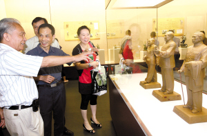 今年7月20日,石灣陶藝回顧展在省博物館開展,參觀者在參觀由中國工藝美術大師劉澤棉(左)等6位國家級陶藝大師共同創(chuàng)作的《東方偉人》作品。(資料圖片)/ 佛山日報記者甘建華攝